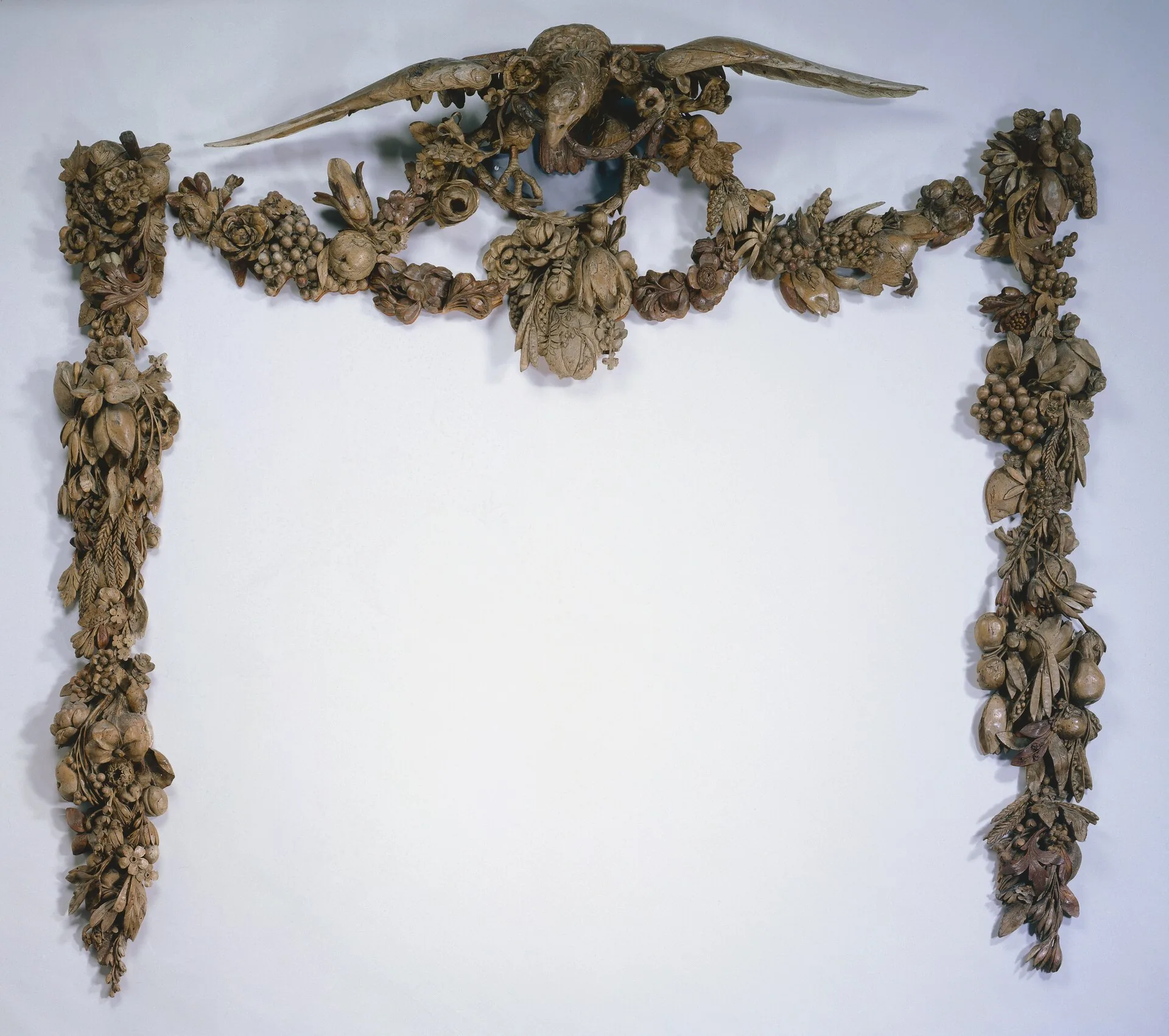 An overmantel carved by Grinling Gibbons: fruit, flowers and foliage cut almost free of the panel behind.
